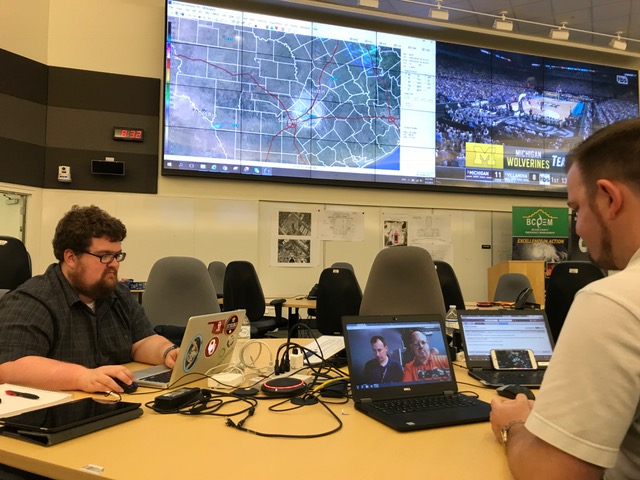 Two onsite forecasters talking with colleagues online