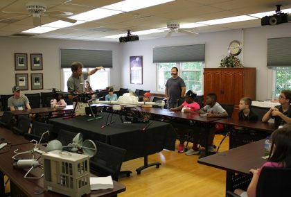 Scientist explaining two drones on table