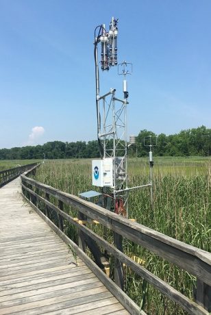 Micrometeorology tower in coastal marsh beside a pier