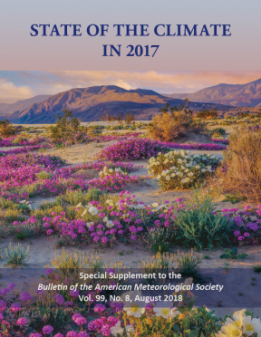 Front cover of the 2017 State of the Climate report. Flowers in the foreground and mountains in the background.