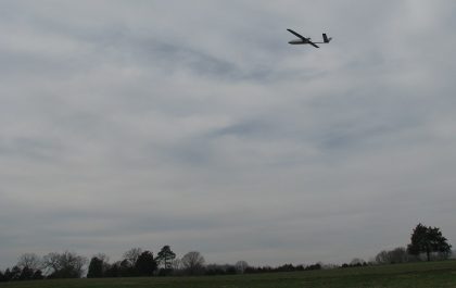 The BlackSwift S2 sUASin flight above a field with a tree line