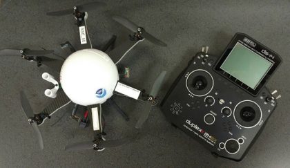 Small, six-arm drone fitted with ATDD's instrumentation sitting beside its controller box.