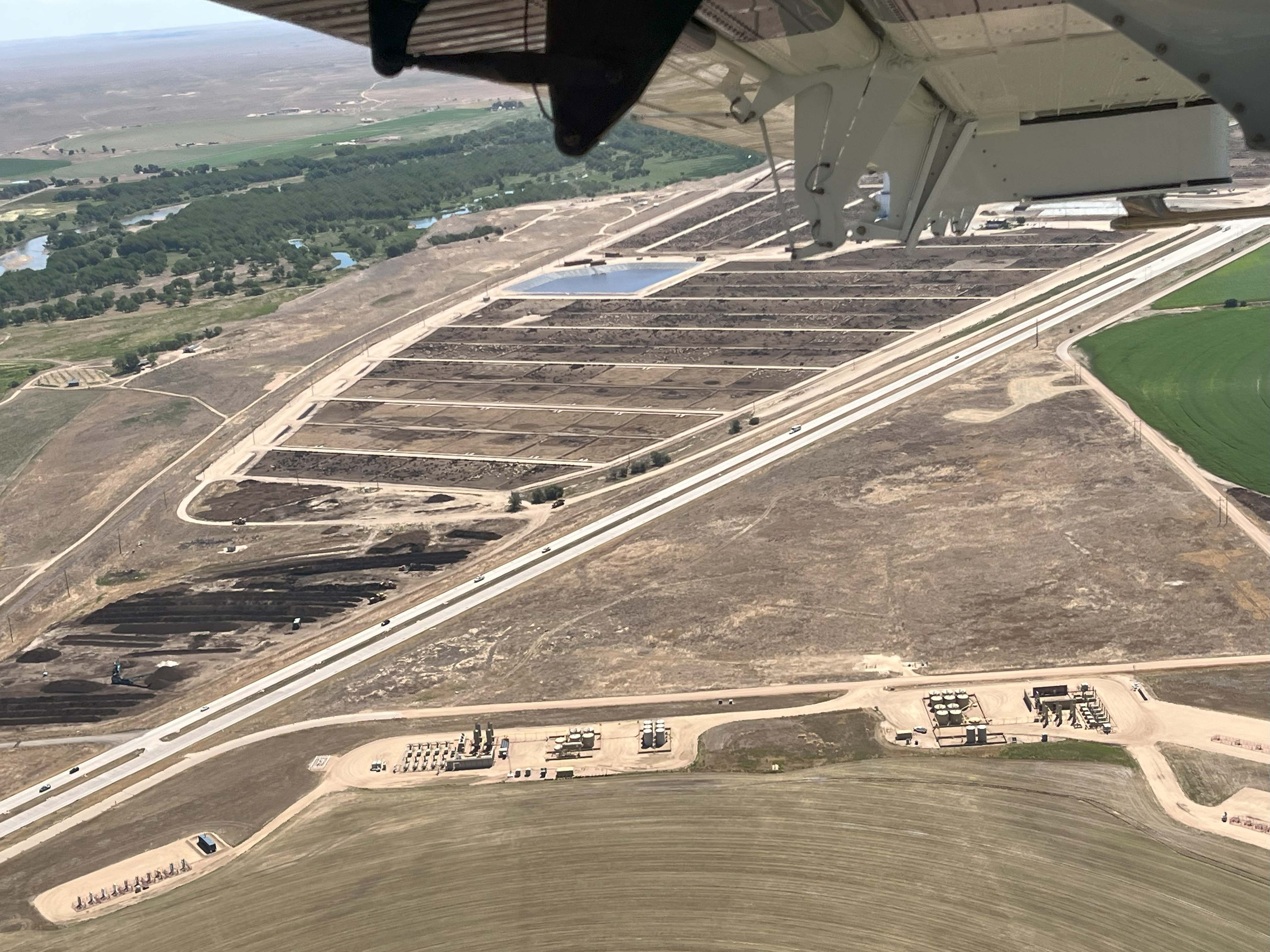 photo taken from inside propeller plane of feedlot below