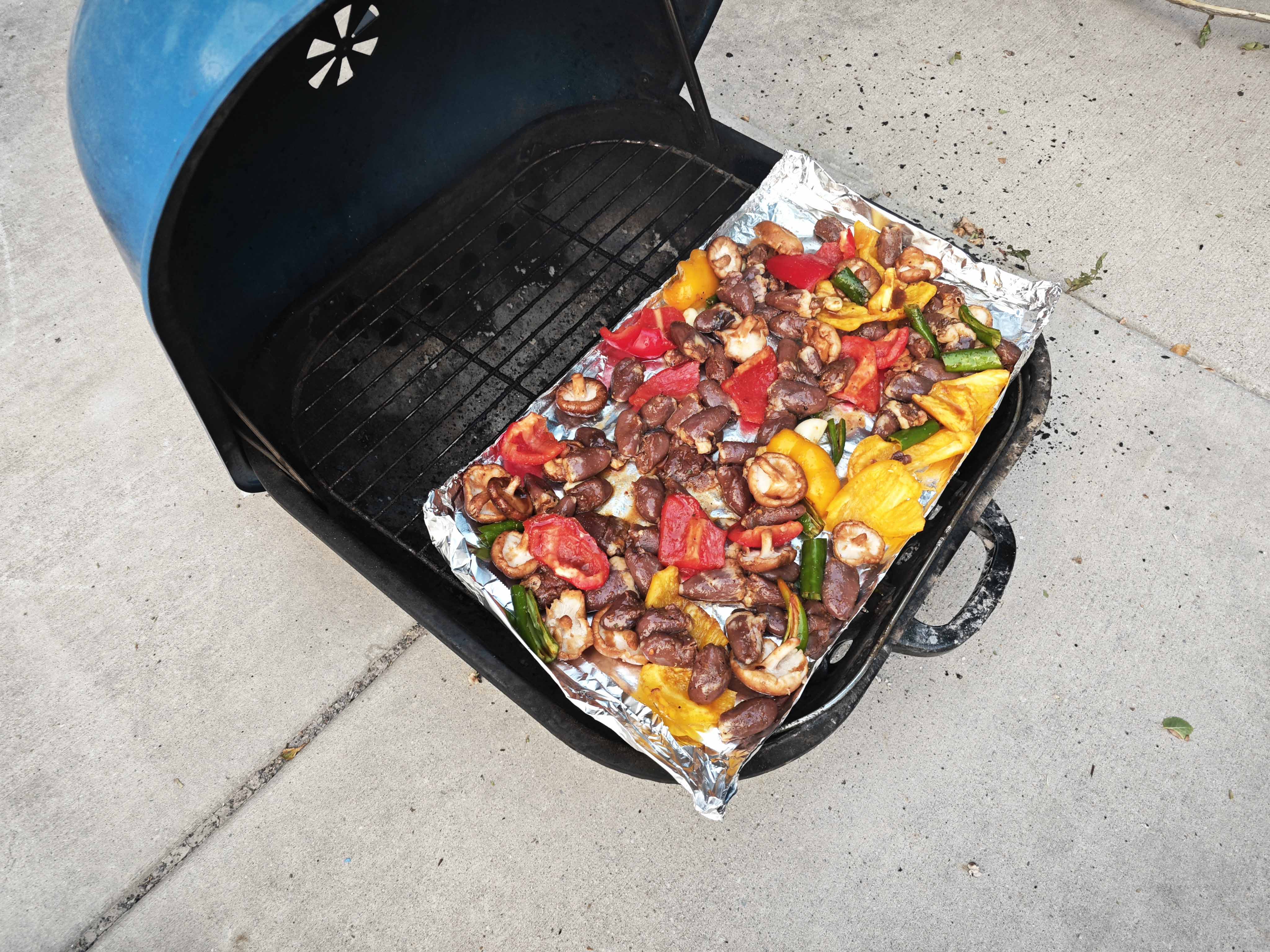 Assortment of meat and vegetables on a portable grill