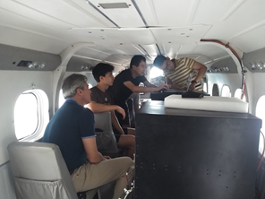 day 7 pic 1 Four men sitting in the cabin of a small plane, making adjustments to instruments
