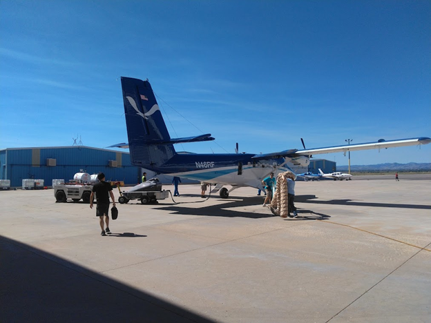 day 7 pic 2 Man walking toward a small NOAA-branded propeller plane