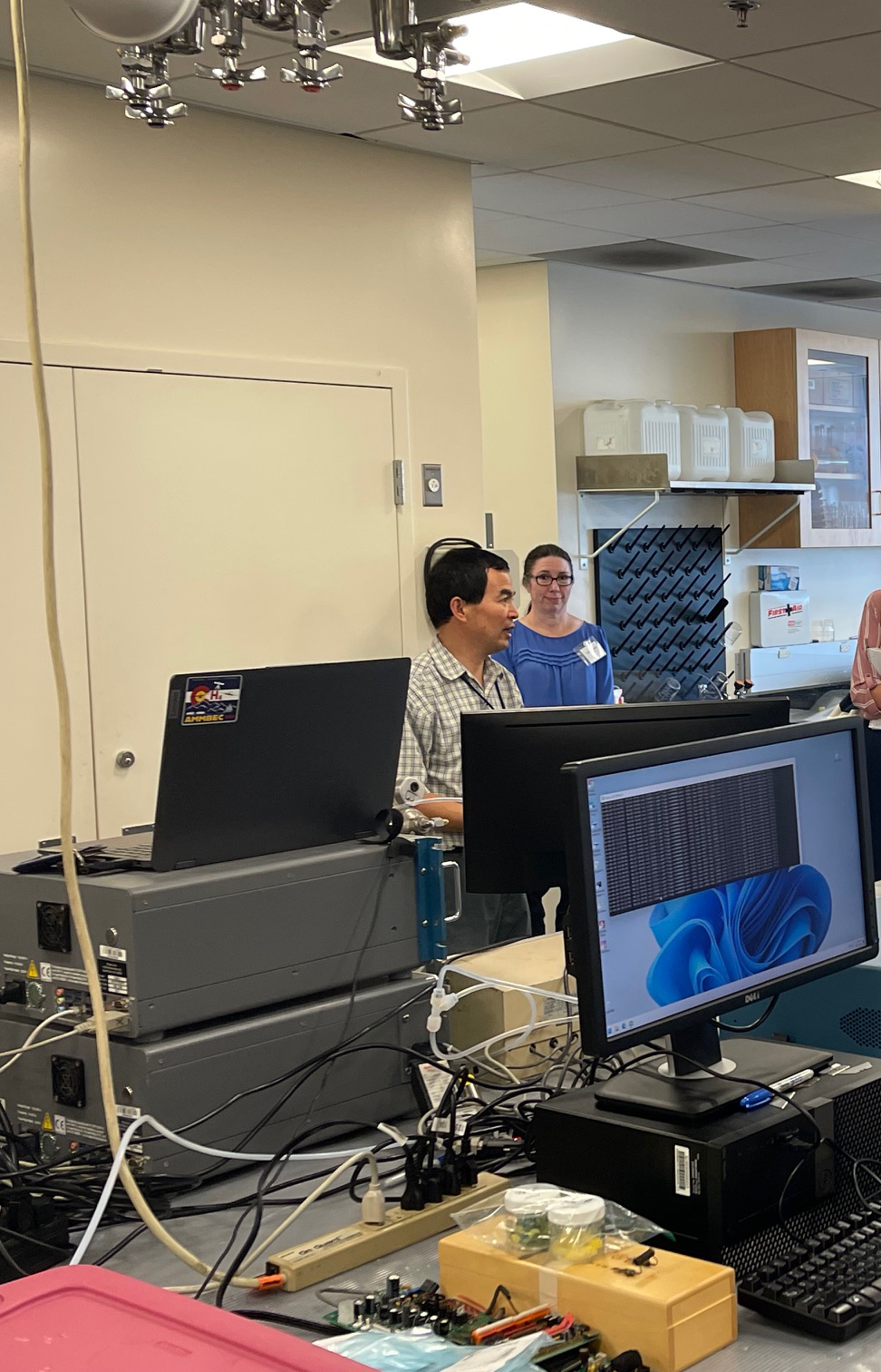 man and woman standing in a lab full of computer equipment